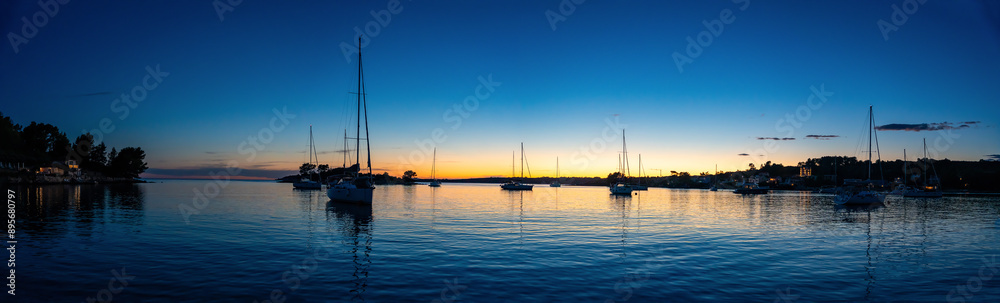 Panorama view of Yachts moored on buoys near the shore in the bay of Uvala Gradina near the town of Vela Luka on the island of Korcula at night time in Croatia Panorama view of Yachts moored on buoys near the shore in the bay of Uvala Gradina near the town of Vela Luka on the island of Korcula at night time in Croatia