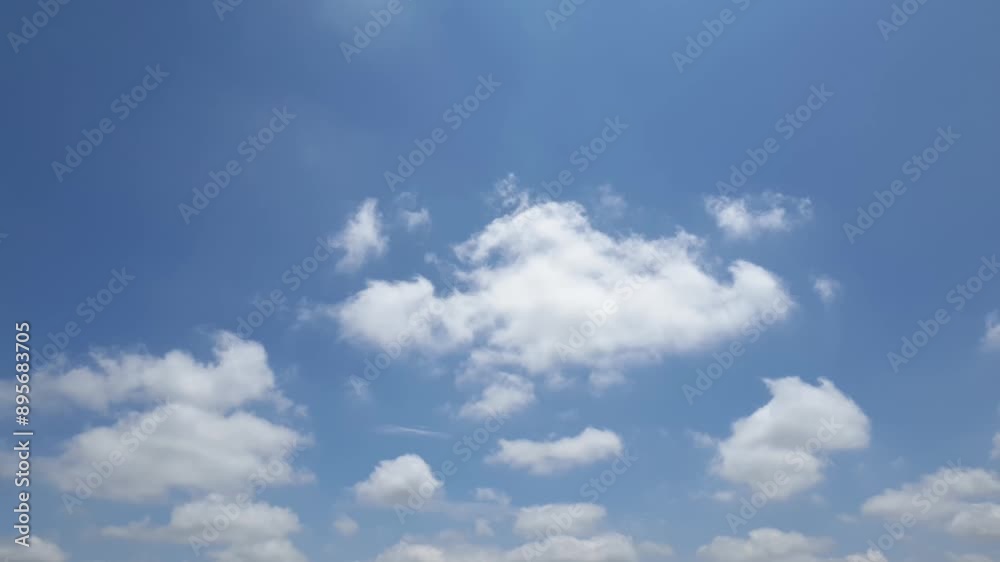 Blue sky in summer with cumulus clouds moving past high above the horizon in a beautiful motion time lapse Blue sky in summer with cumulus clouds moving past high above the horizon in a beautiful motion time lapse