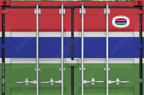 Gambia flag depicted on metal doors of shipping cargo container outdoors in docks area close up photo