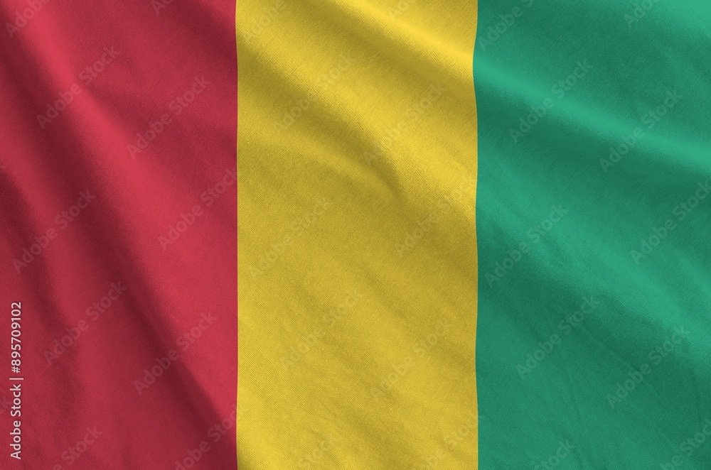 Guinea flag depicted on folded wavy fabric of old cloth close up Guinea flag depicted on folded wavy fabric of old cloth close up