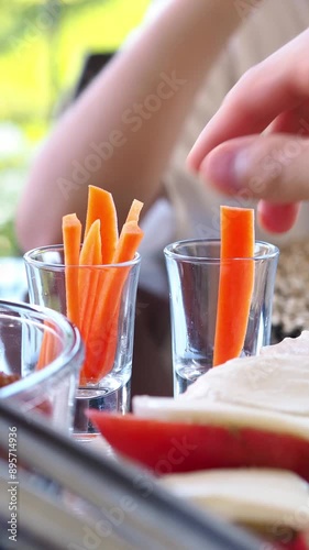 The children take turns slicing carrots. A light snack before the main meal. Proper eating habits. Healthy lifestyle. A source of vitamin A. Vegetables in the diet. Healthy food for a child