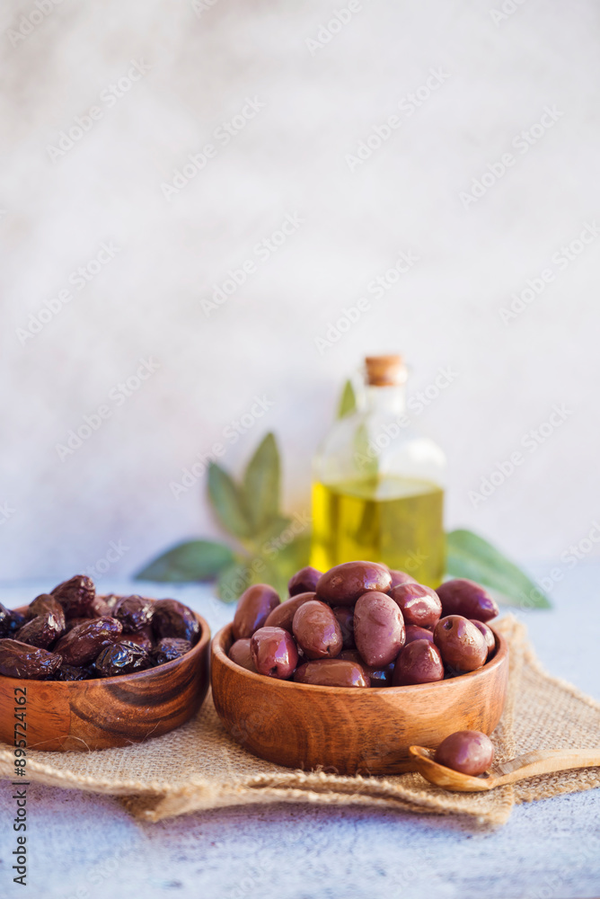 Olives kalamata in wooden bowl and olive oil Olives kalamata in wooden bowl and olive oil