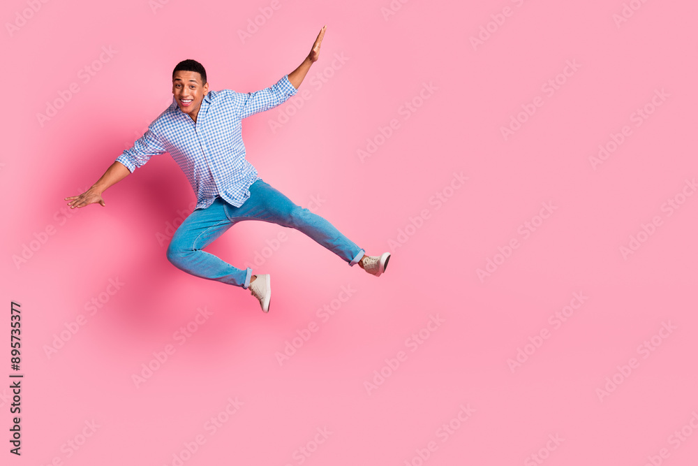 Full length photo of funky impressed guy dressed checkered shirt jumping falling emtpy space isolated pink color background Full length photo of funky impressed guy dressed checkered shirt jumping falling emtpy space isolated pink color background