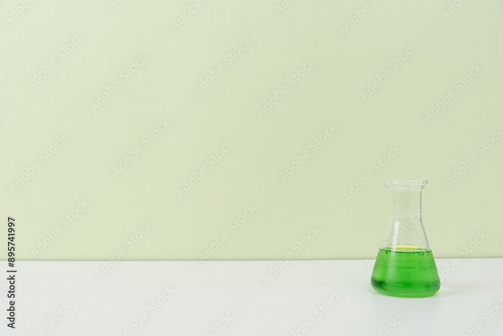 Assorted Laboratory Glassware with Green Liquid on White Surface Assorted Laboratory Glassware with Green Liquid on White Surface