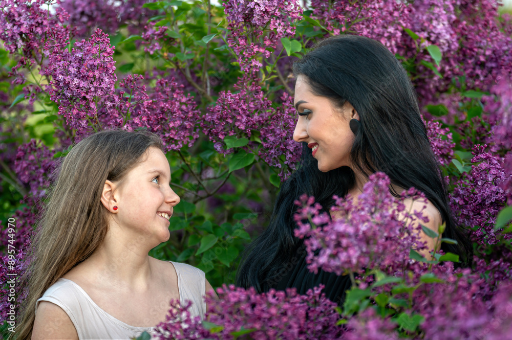 Fototapeta premium Two women in a lilac garden. Shallow depth of feld