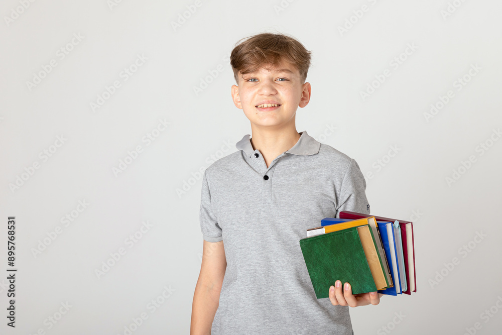 Study, education, school, university, college, graduate concept. Smiling and happy school teen boy with school books in hands on white background, copy space