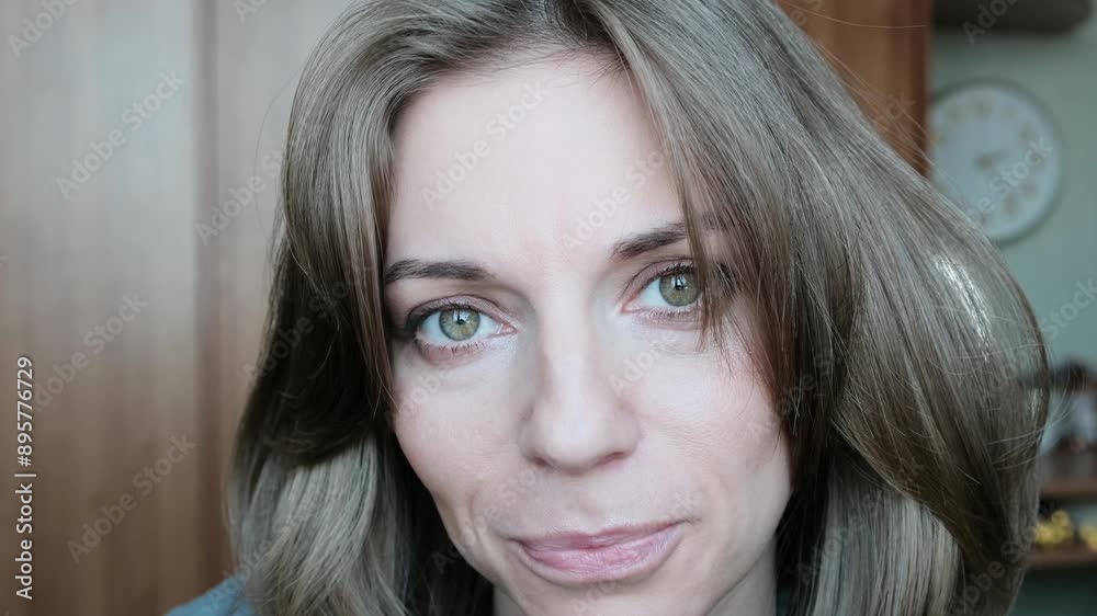 Portrait of a middle-aged woman with green eyes smiling sweetly at the camera. Portrait of a middle-aged woman with green eyes smiling sweetly at the camera.