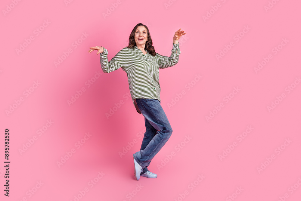 Full size photo of nice aged woman dancing wear shirt isolated on pink color background Full size photo of nice aged woman dancing wear shirt isolated on pink color background