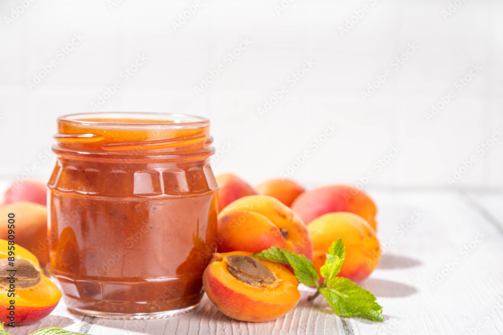Homemade sweet sour apricot chutney jam preserves with spices and raisins, in small jar, with fresh ripe apricots on white wooden table Homemade sweet sour apricot chutney jam preserves with spices and raisins, in small jar, with fresh ripe apricots on white wooden table