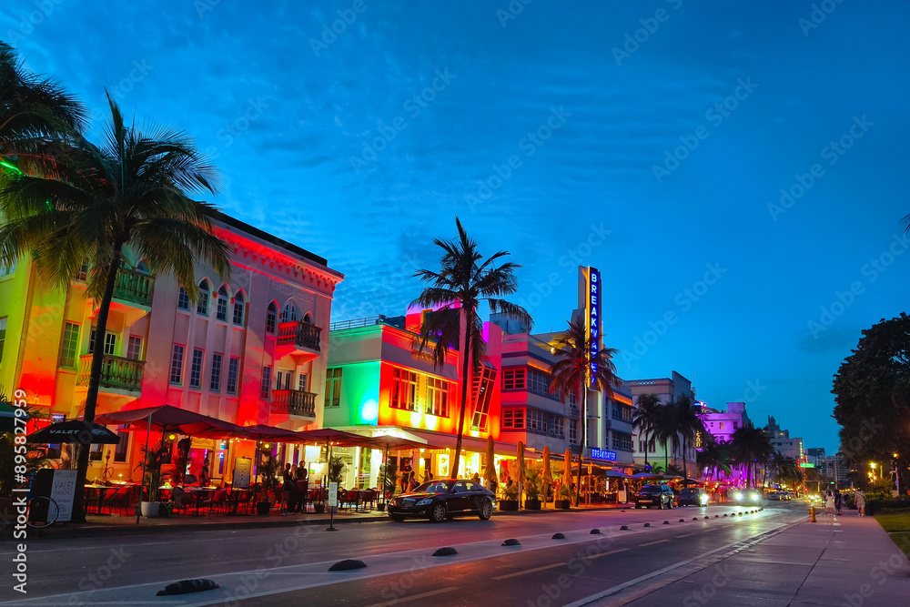 Naklejka premium Miami Beach, Florida - July 8, 2024: Art Deco buildings illuminated at night on Ocean Drive in South Beach