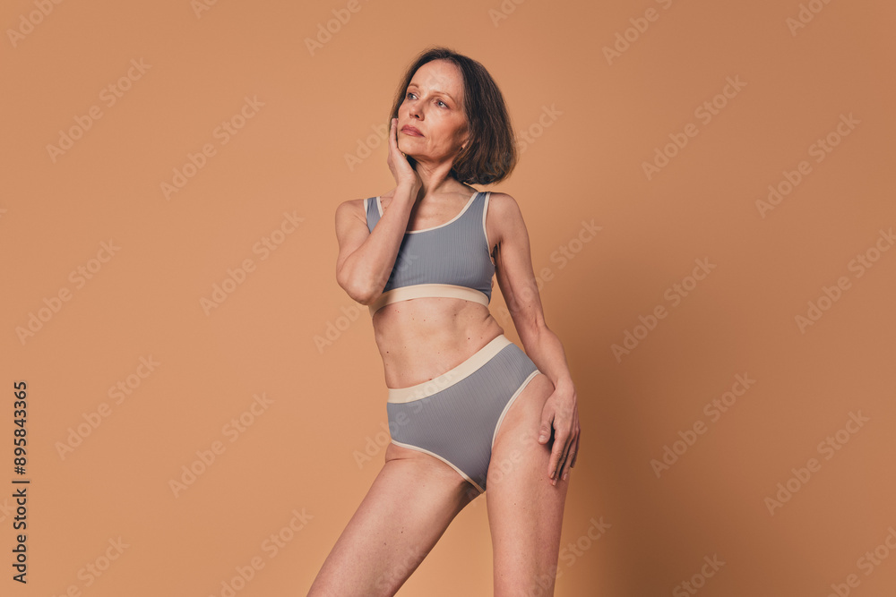 No retouch photo of lovely woman wear grey comfortable lingerie empty space isolated on beige color background No retouch photo of lovely woman wear grey comfortable lingerie empty space isolated on beige color background