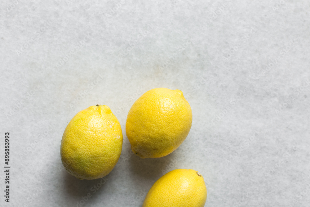 Overhead view of yellow lemons in a white marble countertop, top view of organic lemons in a white background Overhead view of yellow lemons in a white marble countertop, top view of organic lemons in a white background