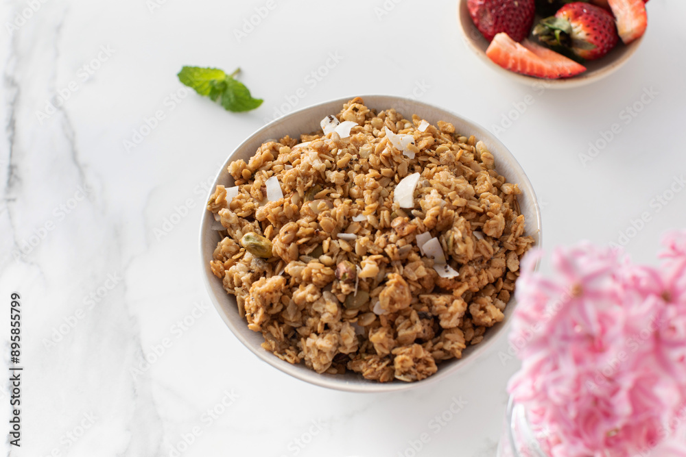 Crispy homemade granola with sliced almonds in a bowl with strawberries. Healthy eating Crispy homemade granola with sliced almonds in a bowl with strawberries. Healthy eating