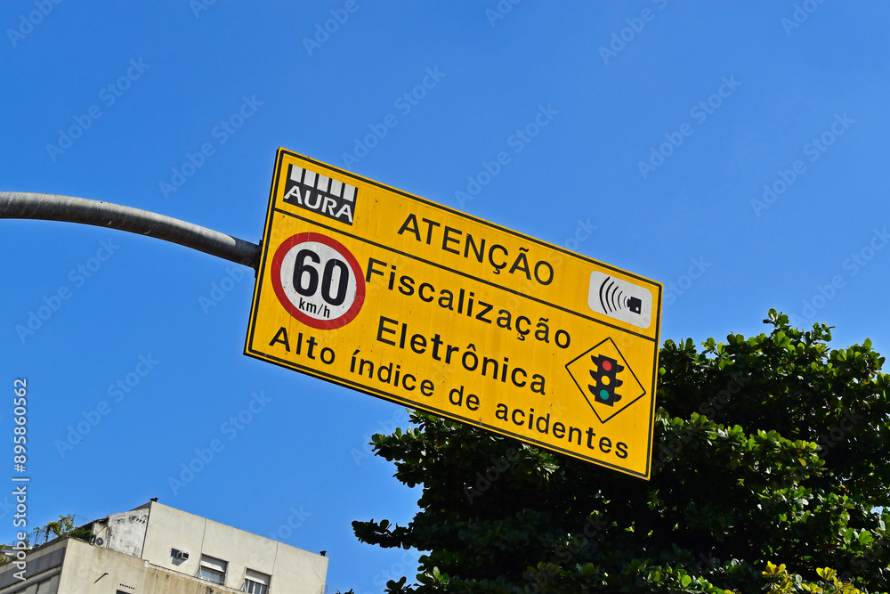 Traffic sign speed limit at 60 kilometers per hour and information in portuguese saying: Attention, electronic inspection, high accident rate