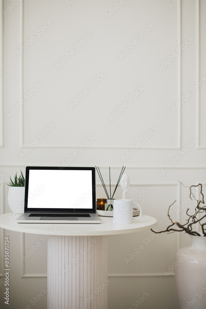 Laptop and white mug with tea on a table. Workspace in a modern room. Laptop and white mug with tea on a table. Workspace in a modern room.