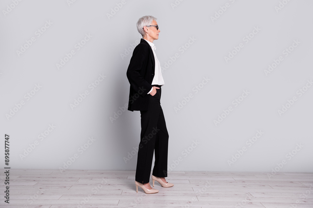 Fototapeta premium Full length photo of confident gorgeous successful lady wear trendy black suit look empty space isolated on grey color background