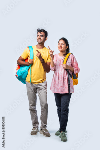 Two Happy Indian College Students with Bags and Laptop, Isolated on White Background