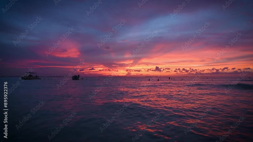 HD video of a spectacular tropical sunset over the sea of many hues and colors from the beach of Mujeres Island in Mexico