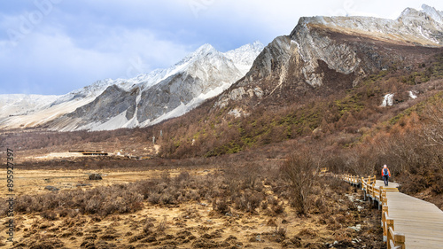 Hiker hiking in the scenic and breathtaking Yading nature reserve Luorong Pasture, located in Garze Tibetan Autonomous Prefecture, Sichuan, China photo