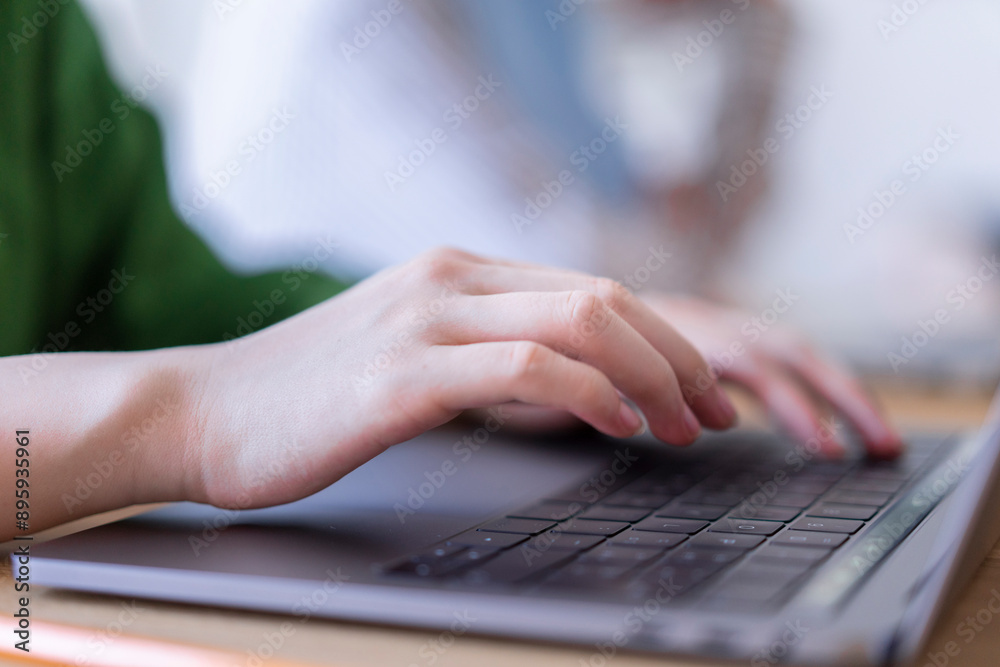 Close-up of a woman's hands typing on a laptop in a modern office setting The focus is on her hands and the technology used for work Close-up of a woman's hands typing on a laptop in a modern office setting The focus is on her hands and the technology used for work