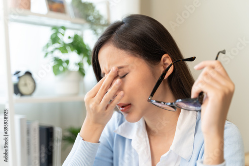 woman taking off glasses tired of computer work suffering from eye strain tension