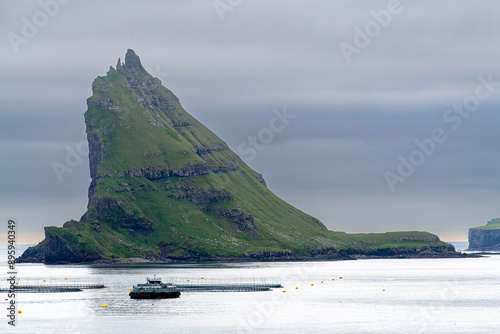 Vistas únicas en  Drangarnir , Isla Vágar en las Islas Faroe: el islote de Tindhólmur un dia de niebla y llovizna.