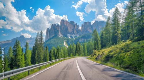 Road in the Dolomites, Italy, on a sunny summer day. Green trees, high rocks, blue sky with clouds. Beautiful travel scene