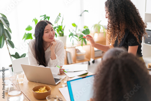 A group of professionals interacting during a team meeting, sharing ideas and discussing plans in a bright office environment, fostering creativity and collaboration photo