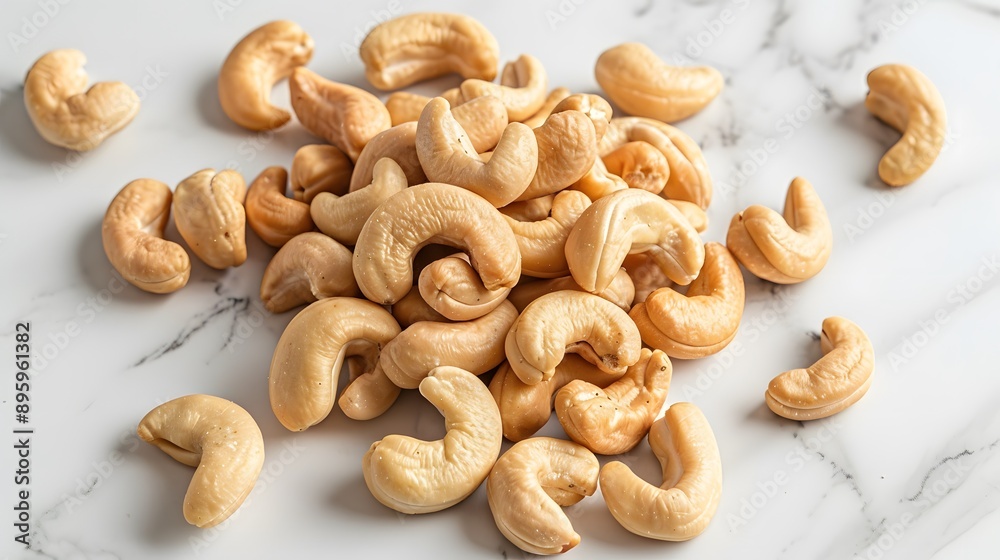 Cashew nuts scattered on a smooth white marble countertop, top-down view, high resolution, sharp focus, studio lighting, food photography. Cashew nuts scattered on a smooth white marble countertop, top-down view, high resolution, sharp focus, studio lighting, food photography.