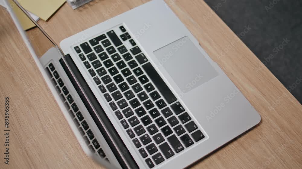 Modern computer standing desk closeup. Grey laptop at office wooden workplace Modern computer standing desk closeup. Grey laptop at office wooden workplace