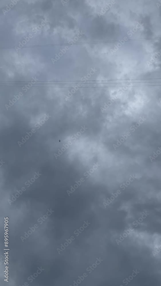 Grey clouds in the sky and a plane is flying Grey clouds in the sky and a plane is flying