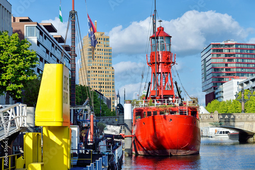 Billede på lærred Red lightship moored inside a city area of Rotterdam