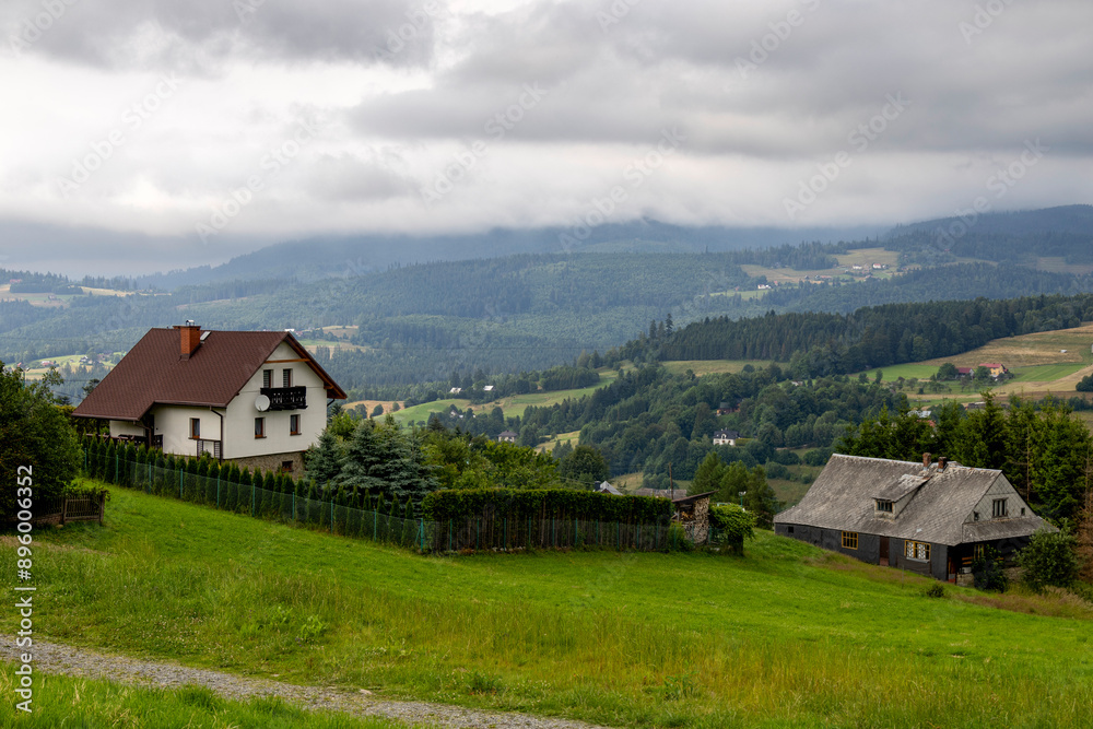 View of koniakow houses with misty hills in the background View of koniakow houses with misty hills in the background