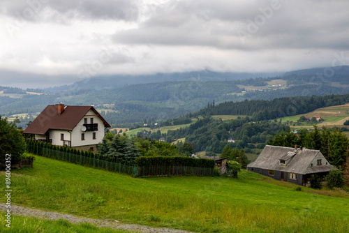 View of koniakow houses with misty hills in the background