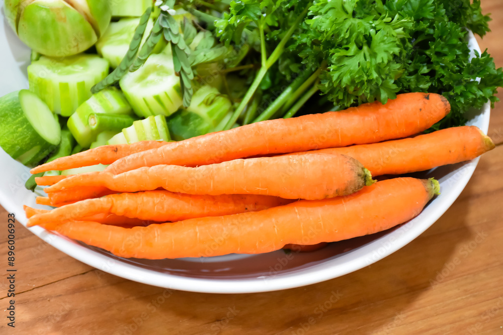 Healthy food: Fresh vegetables rosemary, carrots, brinjal and cucumber in a white ceramic plate. Healthy food: Fresh vegetables rosemary, carrots, brinjal and cucumber in a white ceramic plate.