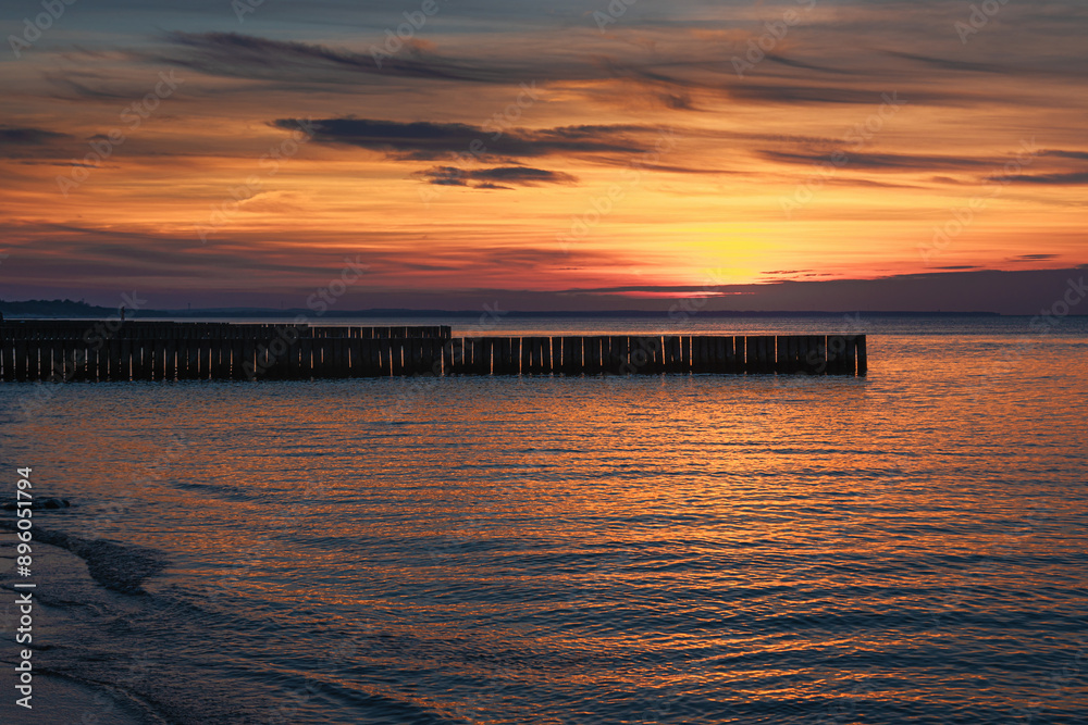View of sand beach with wooden breakwaters on the Baltic Sea coast on sunset in Zelenogradsk. Russia