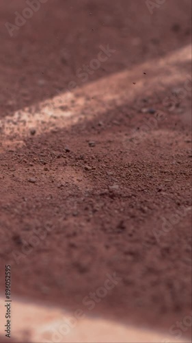 slow motion shot of a tennis ball hitting clay court in vertical photo