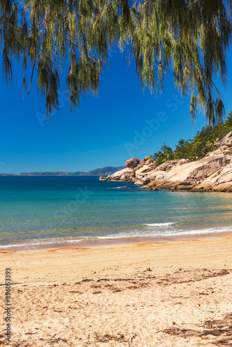 Picturesque golden sandy Alma Beach with granite boulders and turquoise water on Magnetic Island, Queensland, Australia. The island is a holiday destination 8 km offshore of Townsville.