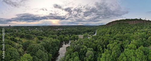 Aerial view of lush forest, river, cliff, and sky at East Rock Park, New Haven, Connecticut, United States.