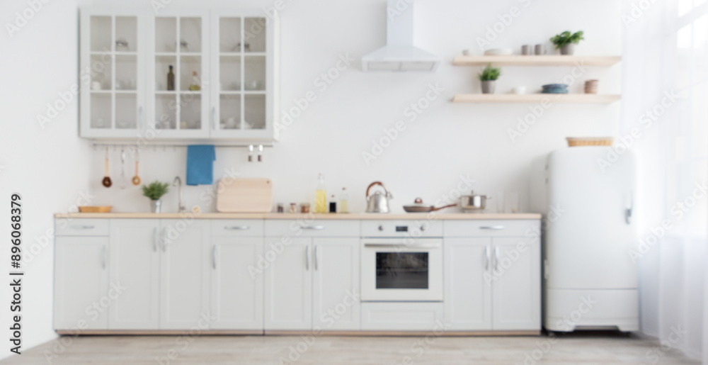 Minimal cozy light home style, scandinavian interior after repair. White furniture with utensils, shelves with crockery and plants in pots, refrigerator in simple dining room, panorama, empty space Minimal cozy light home style, scandinavian interior after repair. White furniture with utensils, shelves with crockery and plants in pots, refrigerator in simple dining room, panorama, empty space