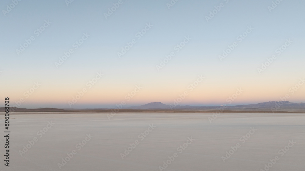 Aerial view of vast salt flat and mountains at dusk, Uyuni, Salar de Uyuni, Bolivia. Aerial view of vast salt flat and mountains at dusk, Uyuni, Salar de Uyuni, Bolivia.