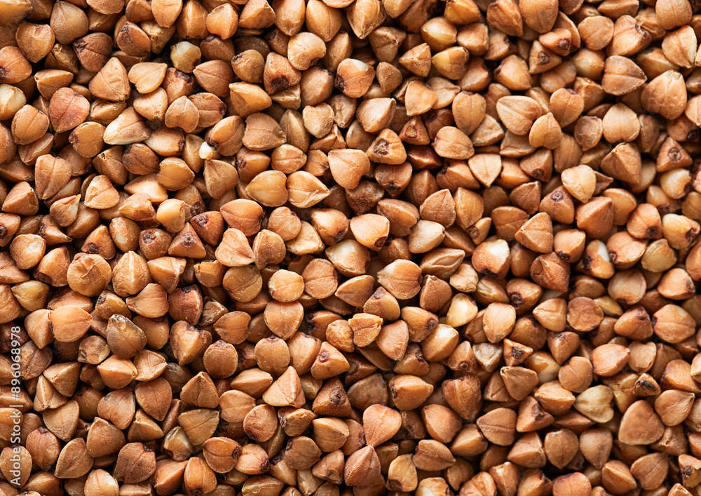 Brown raw healthy buckwheat grain seeds textured background.Macro. Brown raw healthy buckwheat grain seeds textured background.Macro.