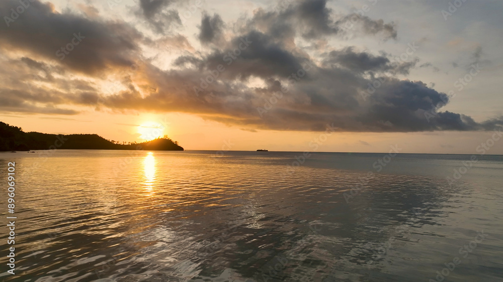 Aerial view of tropical island sunrise over calm sea and golden hour clouds, Fiji. Aerial view of tropical island sunrise over calm sea and golden hour clouds, Fiji.