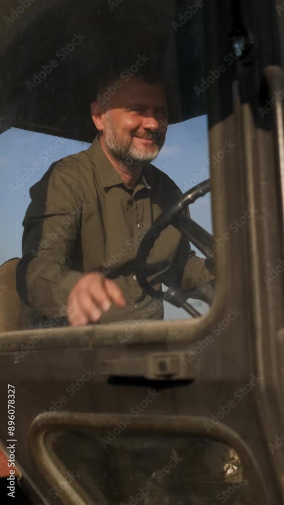 Portrait of satisfied farmer sitting in a tractor preparing to drive. Portrait of satisfied farmer sitting in a tractor preparing to drive.
