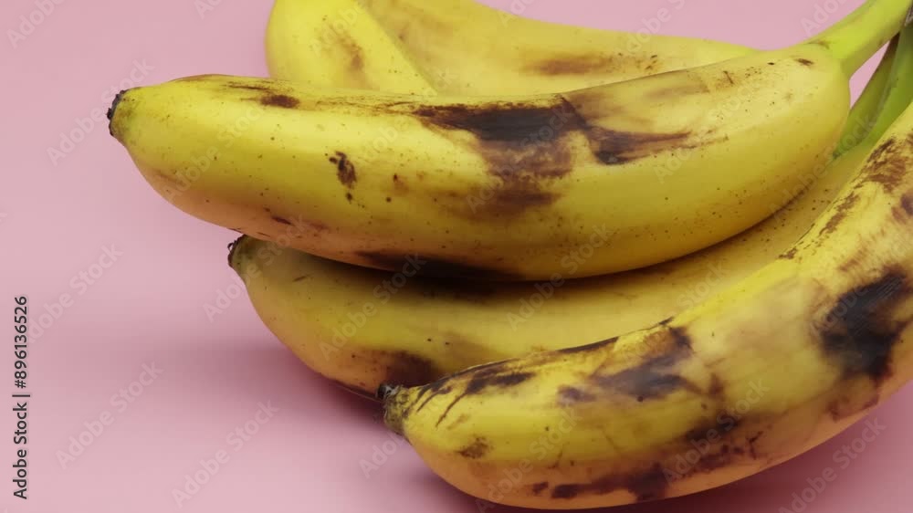 plusieurs bananes bien mûres, en gros plan, sur un fond rose