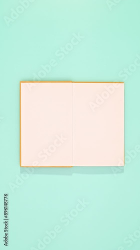 Yellow vintage book appear on cyan background and open. Vertical stop motion