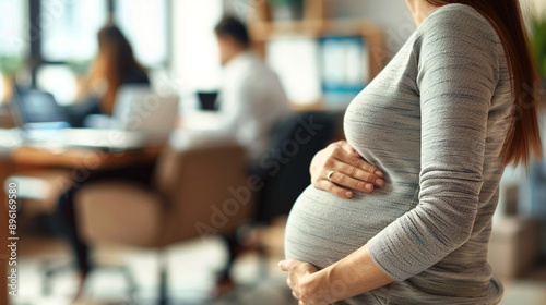 Office Work During Pregnancy. Woman with Late Pregnancy Holds Her Belly with Her Hands. The Problem of No Maternity Leave