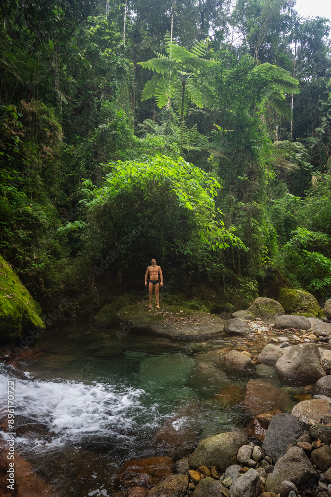 Man bathing on beautiful green waterfall in Atlantic Rainforest Man bathing on beautiful green waterfall in Atlantic Rainforest