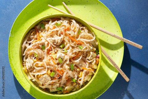 Bright and Sunny Vegetarian Tofu Pad Thai in a lime green bowl and chopsticks photo