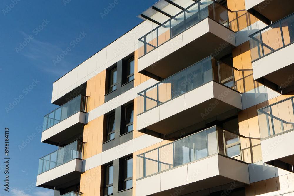 Modern apartment building against a clear blue sky. Residential building architecture. Urban real estate. New build block of flats. Modern living neighbourhood
